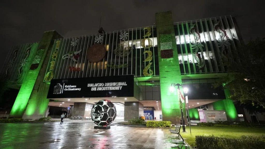 Night view of Palacio Municipal de Monterrey lit in green with a large soccer ball sculpture in front   Informe Regio