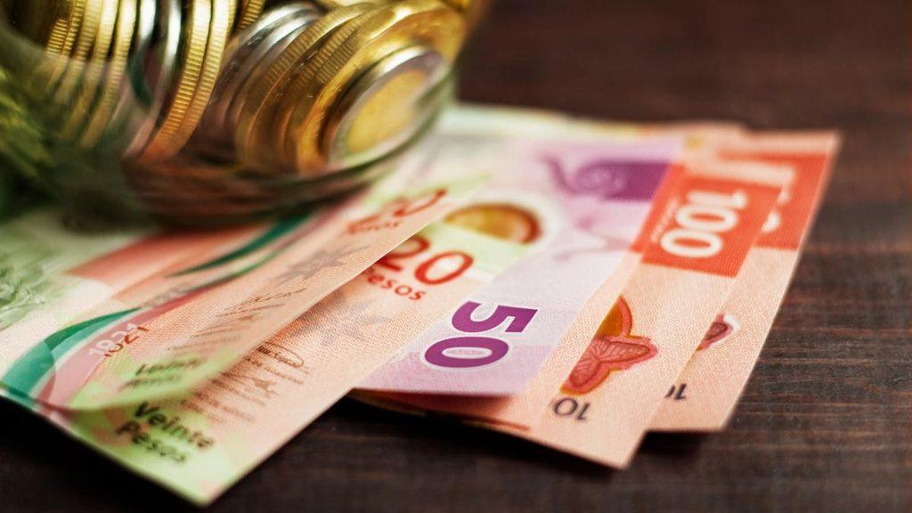Pile of euro banknotes 50 and 100 with coins on a wooden surface   Informe Regio