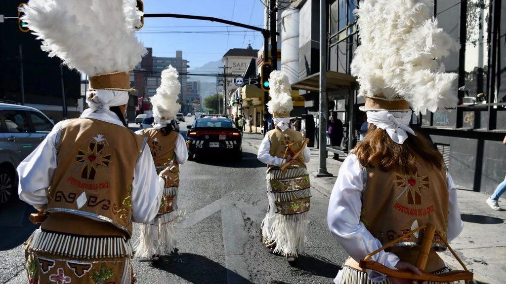 Informe-regio-monterrey-basilica-guadalupe-2026-transitojpg - Informe Regio Group of performers in traditional brown vests and large white feather headpieces marching down a city street playing drums Informe Regio