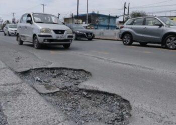 Informe-regio-multas-obras-viales-mal-hechas-congreso-nljpg - Informe Regio Pothole filled urban street with cars driving around a large crater dominates the road surface on a busy avenue Informe Regio