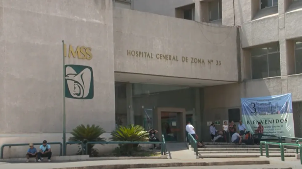 Front of a concrete hospital building with the sign HOSPITAL GENERAL DE ZONA No 33 and an IMSS emblem people seated near the entrance   Informe Regio